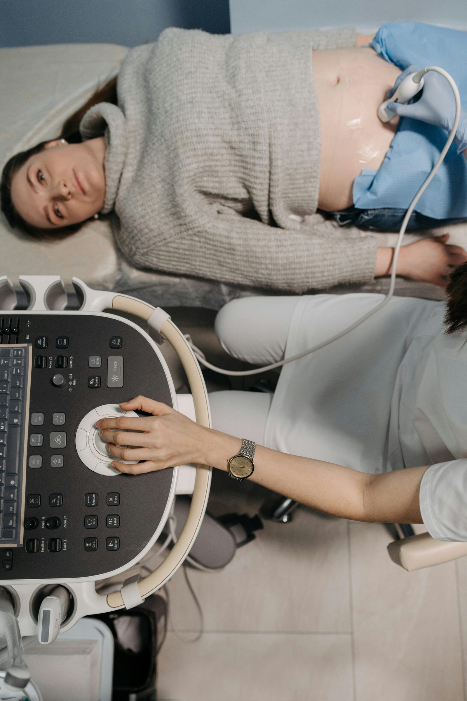 Doctor performing an ultrasound checkup on a female patient in a clinic.